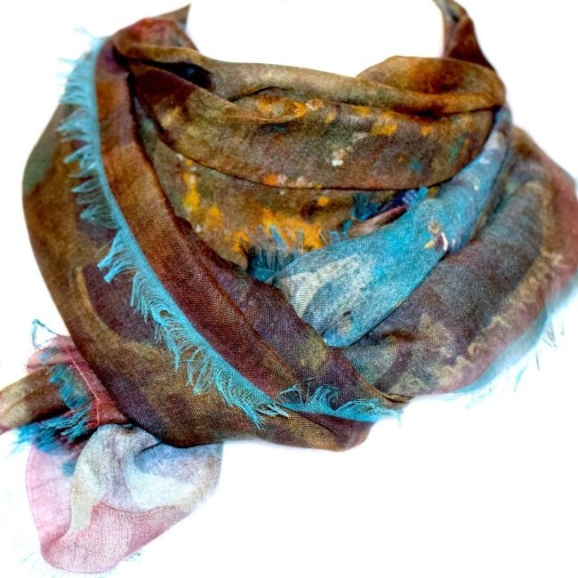 Colorful abstract pattern scarf with fringed edges.