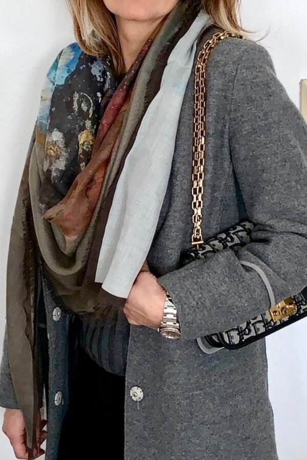 Woman in gray coat with scarf and handbag.