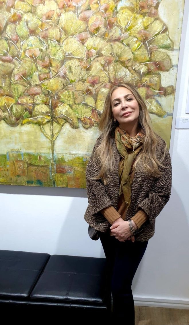 Woman standing by abstract painting in gallery