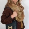 Woman with scarf holding black handbag