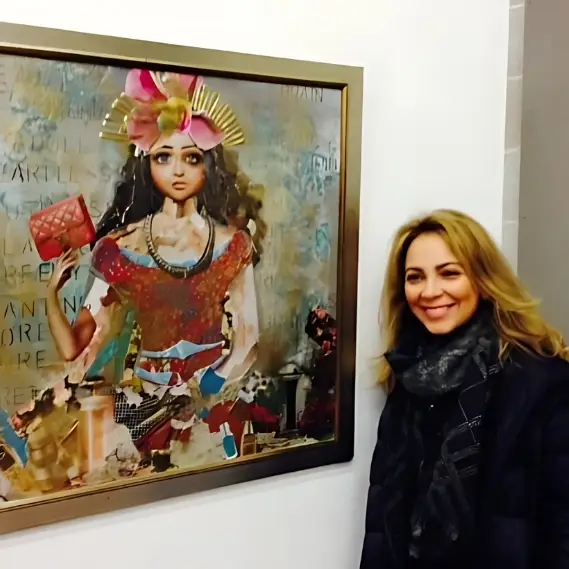 Woman smiling next to colorful art painting on wall.